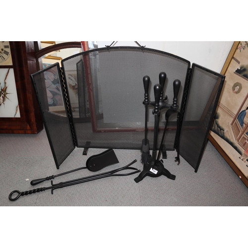 120 - A set of black fire irons and a similar three-fold fire screen