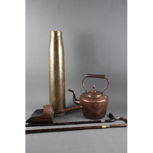 123 - A cast brass shell case stick stand, 23” high, a copper kettle, two silver mounted walking sticks, a... 