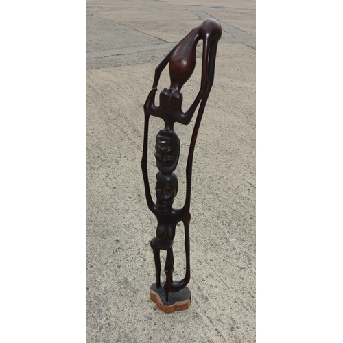 134 - An African carved ebony figure group, 37” high