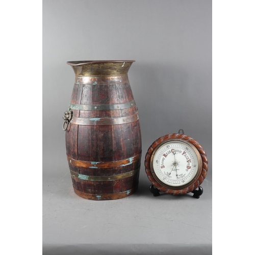 197 - An aneroid barometer, in carved oak case, and a coopered oak stick stand with brass lion mask handle... 