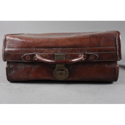 209 - An antique leather case with carry handle, 13 1/2” wide, and a miniature violin and bow, in case