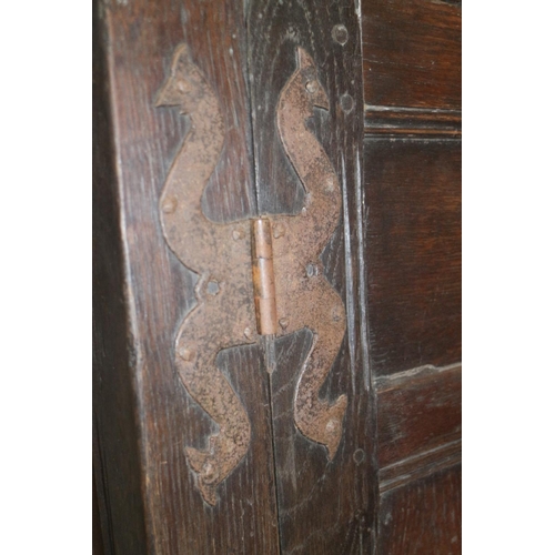 405 - An early 18th century panelled oak wardrobe enclosed two doors with cock head hinges, 45” wide... 