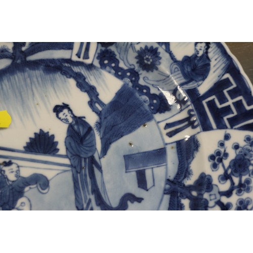 90 - A Chinese blue and white plate with figures in a landscape decoration and panelled borders Cracked a... 