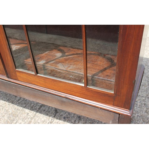 455 - A late Georgian mahogany and inlaid bookcase, the upper section enclosed Gothic lattice glazed doors... 