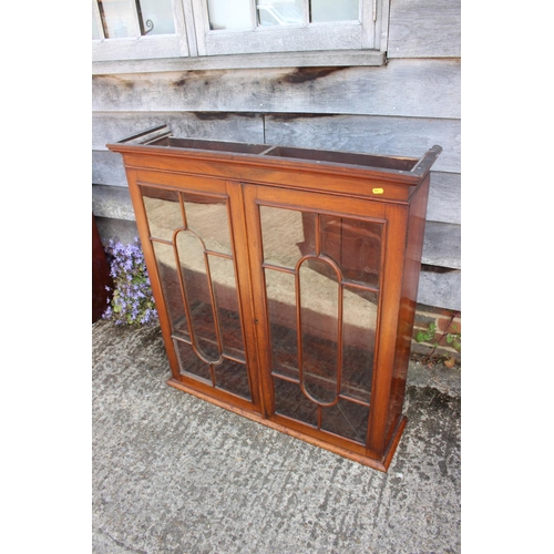 457 - A Victorian mahogany bookcase, the upper section enclosed glazed panelled doors over cupboards, 38” ... 