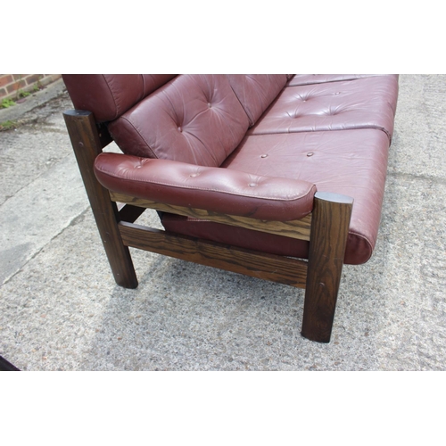 505 - A 1960s Ekornes Scandinavian dark polished ash frame three-seat settee with leather cushions, 79