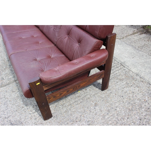 505 - A 1960s Ekornes Scandinavian dark polished ash frame three-seat settee with leather cushions, 79