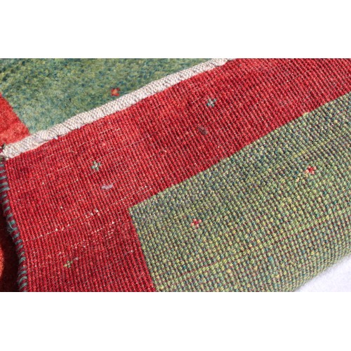 648 - A modern woollen runner with green floral ground design, and green and rust borders, 111