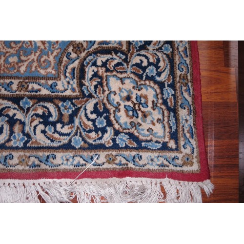 642 - A Persian city rug with scroll design on a red ground and multi-borders, in shades of black, cream a... 