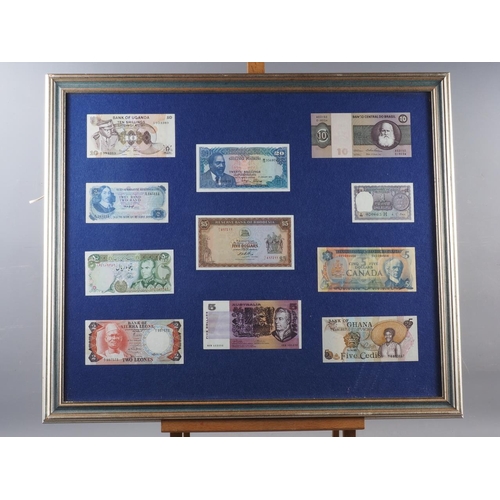 306 - A quantity of bank notes, coins and stamps from around the world, framed, and another similar smalle... 