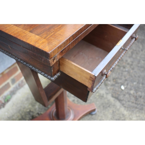 467 - A mid Victorian rosewood work/games table with fold-over top and later well, on quatreform base and ... 