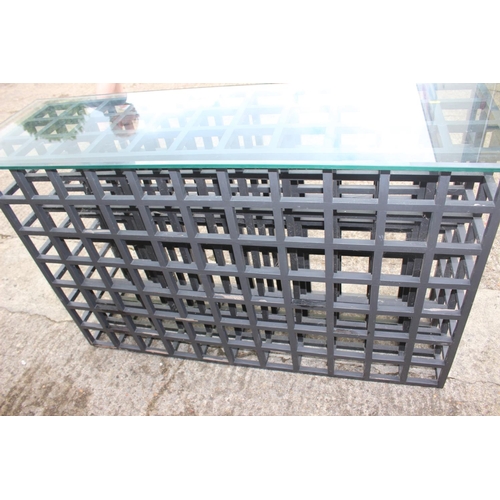 498 - A black painted wooden seventy-seven bottle wine rack with plate glass top, 60