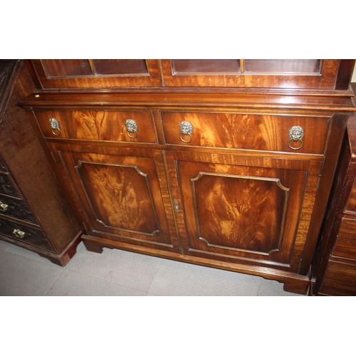 504 - A walnut bookcase of Georgian design, the upper section enclosed lattice glazed doors over two drawe... 