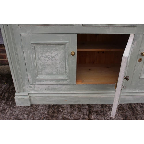 508 - A green painted dresser base with plate glass top, fitted three drawers over three doors, on block b... 