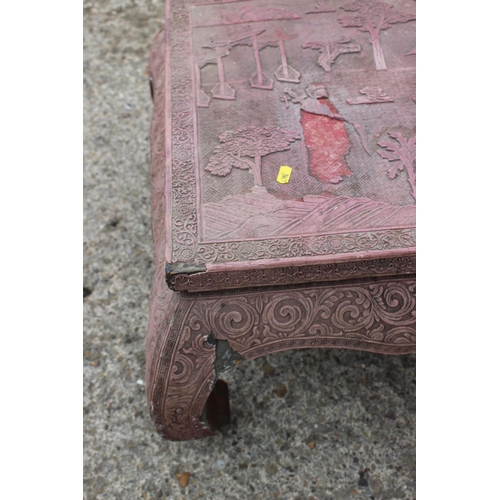 512 - A Chinese carved cinnabar lacquer low occasional table with figure and landscape decoration, on scro... 