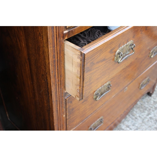 540 - An oak chest of two short and three long graduated drawers with stamped brass handles, on block base... 