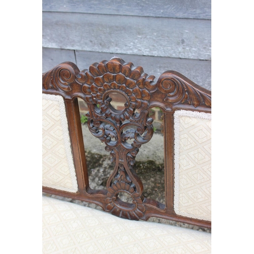 564 - An Edwardian carved walnut showframe two-seat settee with two-panel back, on cabriole castored suppo... 