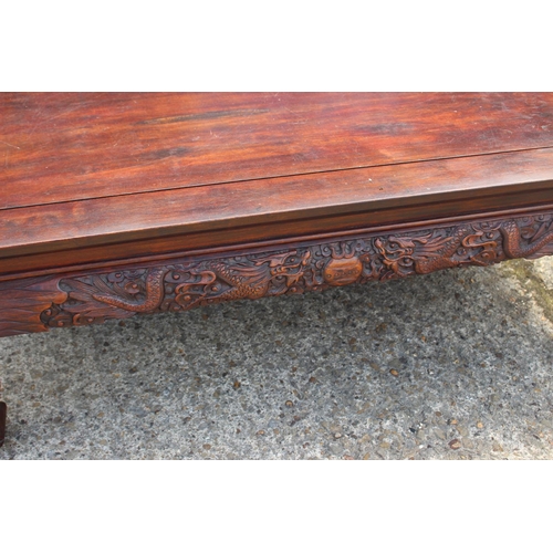 568 - A Chinese carved hardwood low table with dragon masks and paw feet, 47