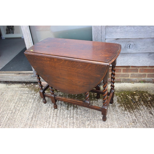 581 - An oak oval drop leaf table, on barley twist gate leg supports, 46