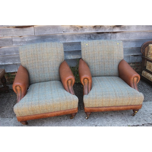 588 - A pair of leather and Harris tweed upholstered deep seat armchairs, on turned and castored supports