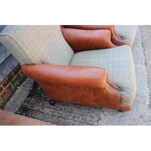 588 - A pair of leather and Harris tweed upholstered deep seat armchairs, on turned and castored supports