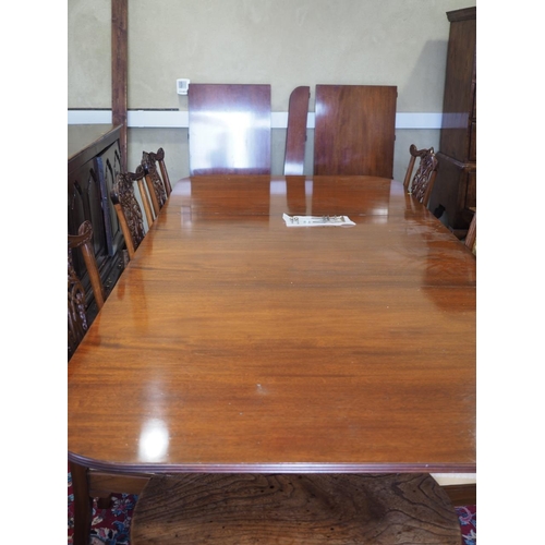 597 - An early 20th century mahogany triple pedestal dining table with two extra leaves, on turned columns... 