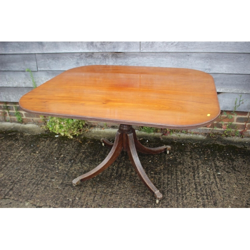 606 - A mahogany breakfast table of Georgian design, on turned column and quadruple splay castored support... 