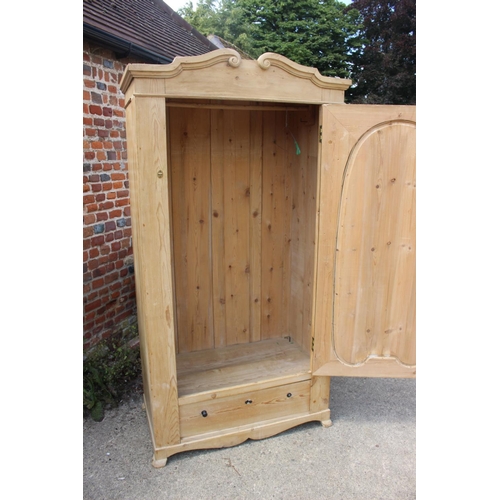 612 - A stripped pine wardrobe, fitted single door over one long drawer, on stile supports, 39