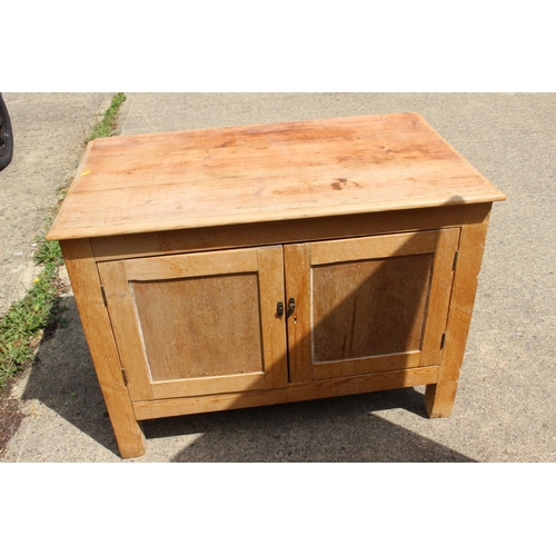 613 - A stripped pine side cupboard, fitted two doors, on square supports, 40