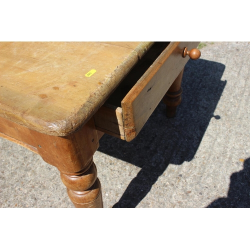 623 - A 19th century waxed pine kitchen table, fitted one drawer, on turned supports, 48