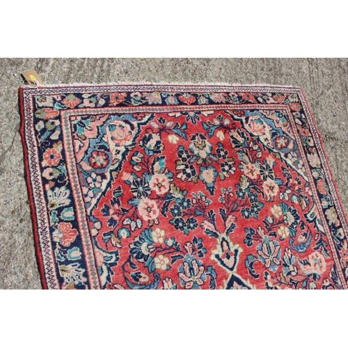 653 - A Persian rug with all-over floral design on a salmon ground and triple borders, 80