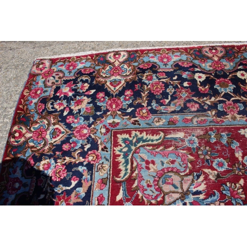 671 - A Persian city rug with floral design on a claret ground with deep borders, 118