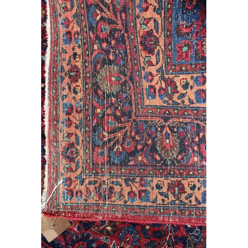 673 - A Kirman rug with all-over floral design and central white star medallion on a red ground and multi-... 