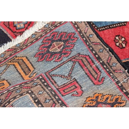 674 - A Caucasian rug with three red medallions on a black ground, and bird and floral border on a light b... 