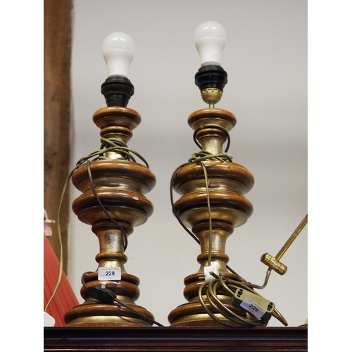 229 - A pair of turned hardwood and gilt painted table lamps, 19