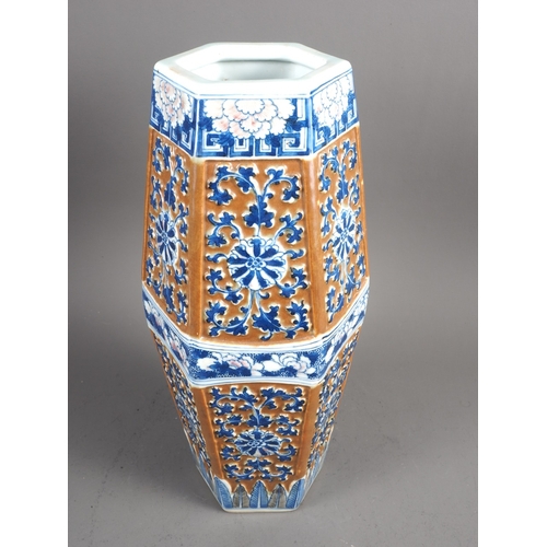 66 - A Chinese blue and white relief decorated hexagonal vase with cafe-au-lait ground, 13 1/2