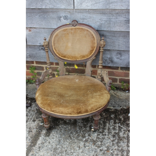 438 - A Victorian carved walnut low seat occasional chair with oval panel back, on turned and castored sup... 