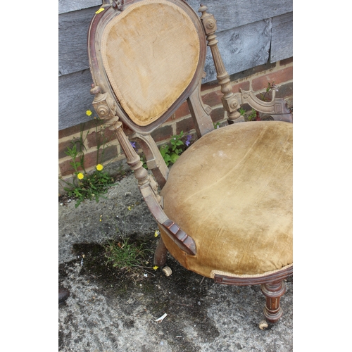 438 - A Victorian carved walnut low seat occasional chair with oval panel back, on turned and castored sup... 