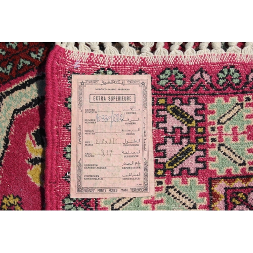 637 - A Moroccan carpet of traditional design with eight central medallions on a pink ground, 61