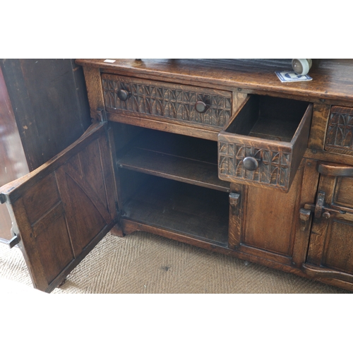 474 - A well reproduced oak ledge back sideboard, fitted two carved side drawers and central smaller drawe... 