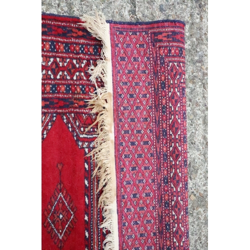 659 - A Bokhara rug with five medallions on a red ground and multi-borders, 49