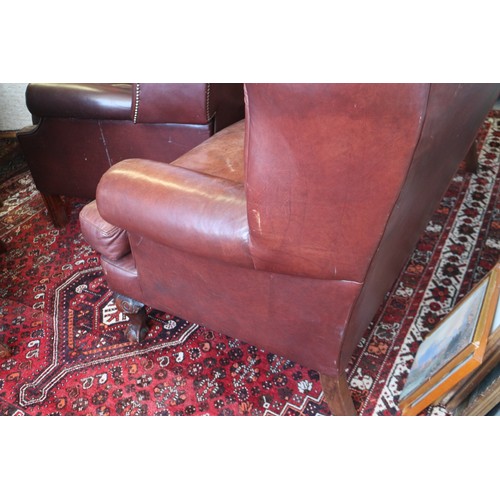 493 - A leather upholstered settee with two shaped cushions and twelve-panel shaped and stitched back, on ... 