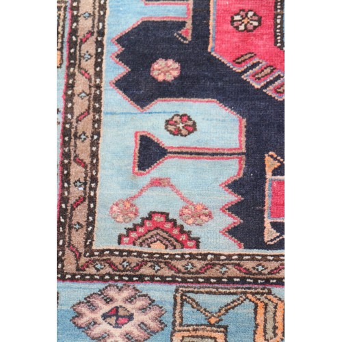 674 - A Caucasian rug with three red medallions on a black ground, and bird and floral border on a light b... 