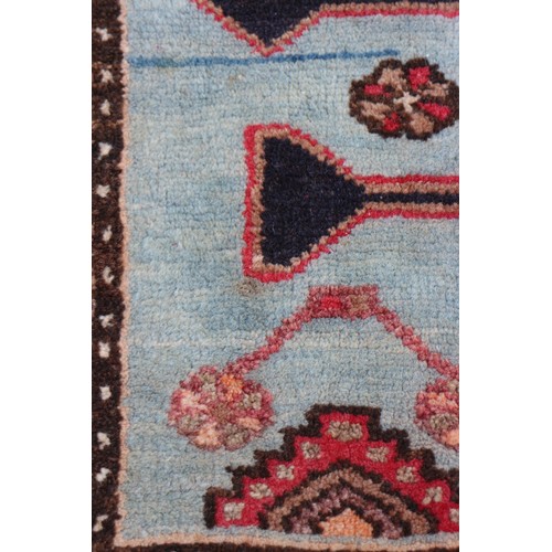 674 - A Caucasian rug with three red medallions on a black ground, and bird and floral border on a light b... 