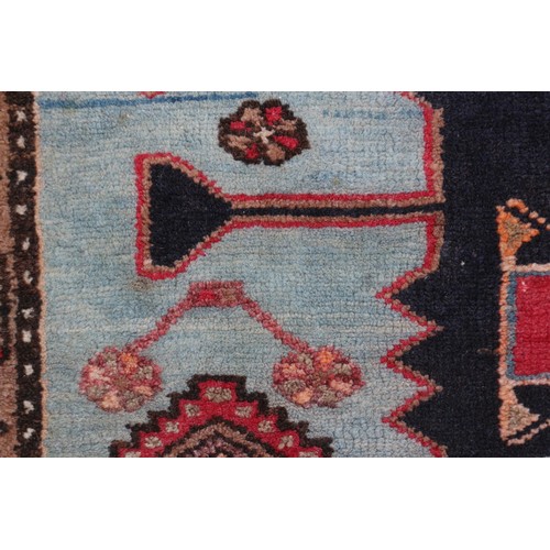 674 - A Caucasian rug with three red medallions on a black ground, and bird and floral border on a light b... 