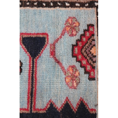 674 - A Caucasian rug with three red medallions on a black ground, and bird and floral border on a light b... 