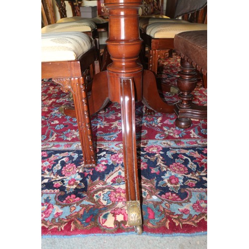 597 - An early 20th century mahogany triple pedestal dining table with two extra leaves, on turned columns... 