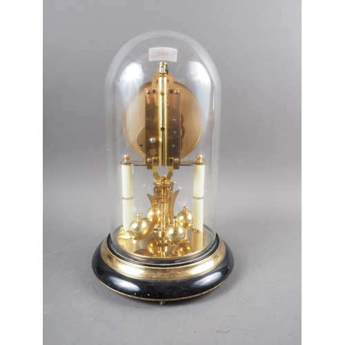 105 - A brass anniversary clock with glass dome, 12