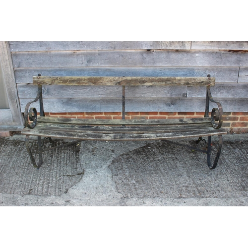 683 - A wrought iron slatted garden bench, on scroll end supports, 72