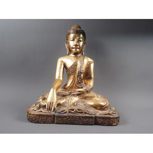 88 - An Oriental carved wood figure of a seated Buddha with gilt and jewelled decoration, 16